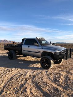 a silver truck parked in the middle of a desert