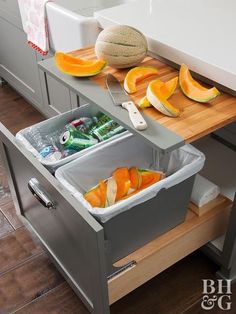 a kitchen counter with two bins filled with fruit