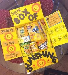 a box of sunshine is sitting on top of a table with some snacks in it