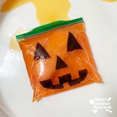 a plastic bag with a jack - o'- lantern face on it sitting on a plate