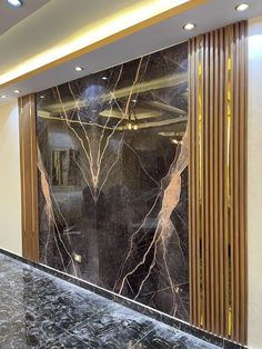 a marble counter top in front of a glass wall with gold foiling on it