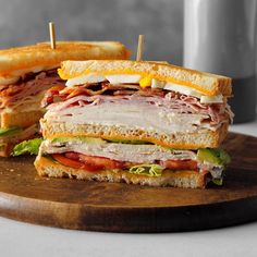 a cut in half sandwich sitting on top of a wooden cutting board