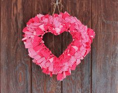 a heart shaped wreath hanging on a wooden door