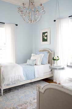 a bedroom with blue walls and white furniture