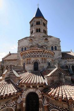 an old building with a clock tower on it's side and tiled roof tops