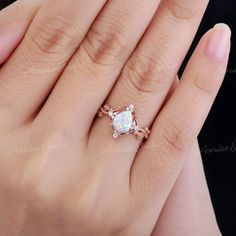 a woman's hand with a ring that has an opal stone in it