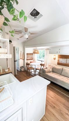 a living room filled with furniture and a ceiling fan