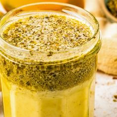 a glass jar filled with pesticides on top of a wooden table next to other spices