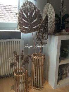 three vases made out of bamboo sticks on a wooden floor next to a radiator