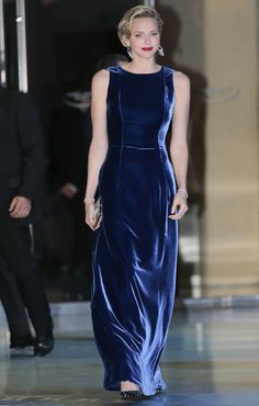 a woman in a blue dress walking down the runway