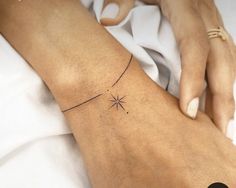 a woman's arm with a small star tattoo on the left side of her arm