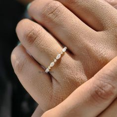 a woman's hand with a diamond ring on top of her finger and the other hand holding it