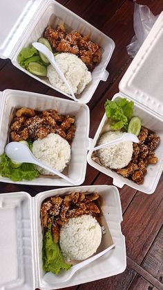 four plastic containers filled with food on top of a wooden table