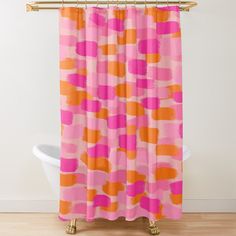 a pink and orange shower curtain with an abstract design on the bottom, in front of a white bathtub