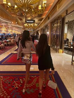 two women are standing in the middle of a shopping mall