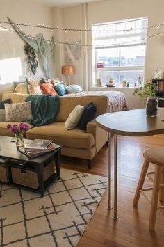 a living room filled with furniture next to a table and chair in front of a window