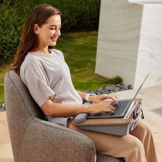 a woman sitting in a chair with a laptop on her lap