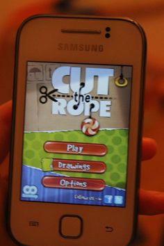 someone is playing cut the rope on their cell phone