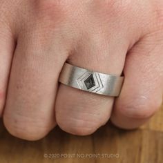 a person's hand with a silver ring on it