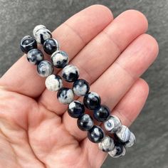 "Polished beads made from orca agate (thought to be a variety of blue chalcedony). 8mm Bracelets Sized: 6.50 - 6.75\" Our crystals and minerals are natural, and some are shaped by hand. Because each is unique and one of a kind, some may come with small chips or imperfections. Any appearances of cracks are one of the natural characteristics of this crystal or mineral and not because of damage. We select all crystals and minerals by hand. We choose the most unique and highest quality we can find. Casual Agate Beaded Bracelets With Round Beads, Casual Agate Beaded Bracelets, Adjustable Casual Agate Stretch Bracelet, Casual Adjustable Agate Stretch Bracelet, Casual Hand-strung Agate Bracelet, Handmade Casual Agate Stretch Bracelet, Casual Round Agate Beaded Bracelets, Casual Black Agate Beaded Bracelets, Orca Agate