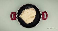 a pan with some food in it on the stove top next to a red spatula