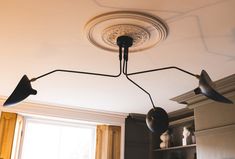 three lights hanging from the ceiling in a room with white walls and cabinets behind them