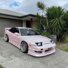 a pink car parked in front of a house