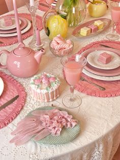 the table is set with pink and white dishes, plates, cups, and utensils