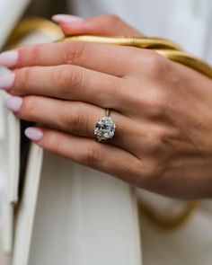 a close up of a person's hand with a ring on it