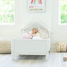 A young girl is laying in the Lil House Toddler Bed. Crib To Toddler Bed, Ground Design, Playground Safety, Floor Bed Frame, White Bunk Beds, Bed Floor, Kids Flooring, Learning Tower, Fun House