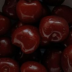 a pile of red apples sitting on top of each other with water droplets all over them