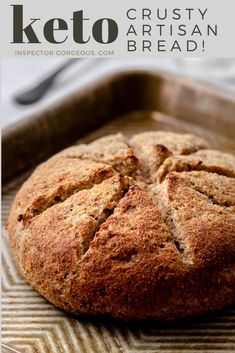 a close up of a loaf of bread on a pan with the words keto crusty artisan bread