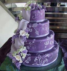 a purple wedding cake with white flowers on it