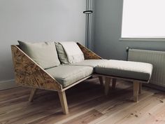 a couch and ottoman in a room next to a radiator with a window