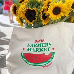 a white bag with some sunflowers in it