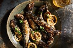 grilled fish with lemon slices and herbs on a plate