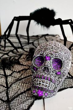 a purple and black skull sitting on top of a spider web