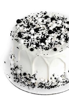 a cake with white frosting and black sprinkles