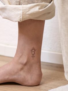 a woman's foot with a small tattoo on the side of her leg,