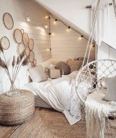 a bedroom with a bed, chair and hanging lights in the ceiling is decorated with wicker baskets