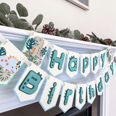 a happy 5th birthday banner hanging from a mantel with succulents and leaves