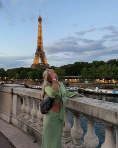 a woman taking a photo of the eiffel tower