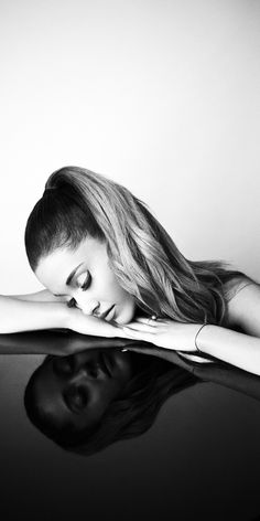 black and white photograph of a woman leaning on top of a table with her head in her hands