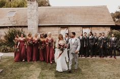 a group of people standing around each other in front of a building with flowers on it