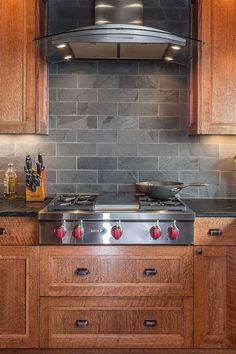 a stove top oven sitting inside of a kitchen next to wooden cabinets and counter tops