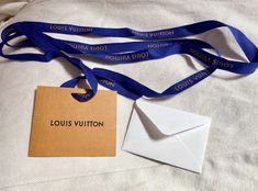 the louis vuitton necklace is next to an envelope with a name tag on it