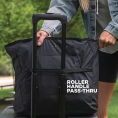 a person holding onto a rolling bag on top of a black suitcase with the words roller handle pass thru