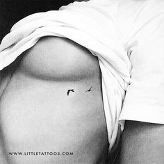 a woman's stomach with a small bird tattoo on it