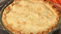 an uncooked pie sitting on top of a table next to a knife and fork