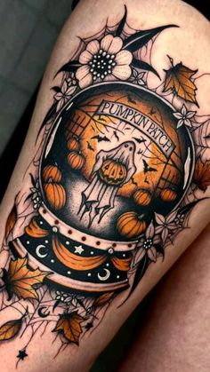 a woman's thigh with an orange and black tattoo design on her leg that reads, pumpkin harvest